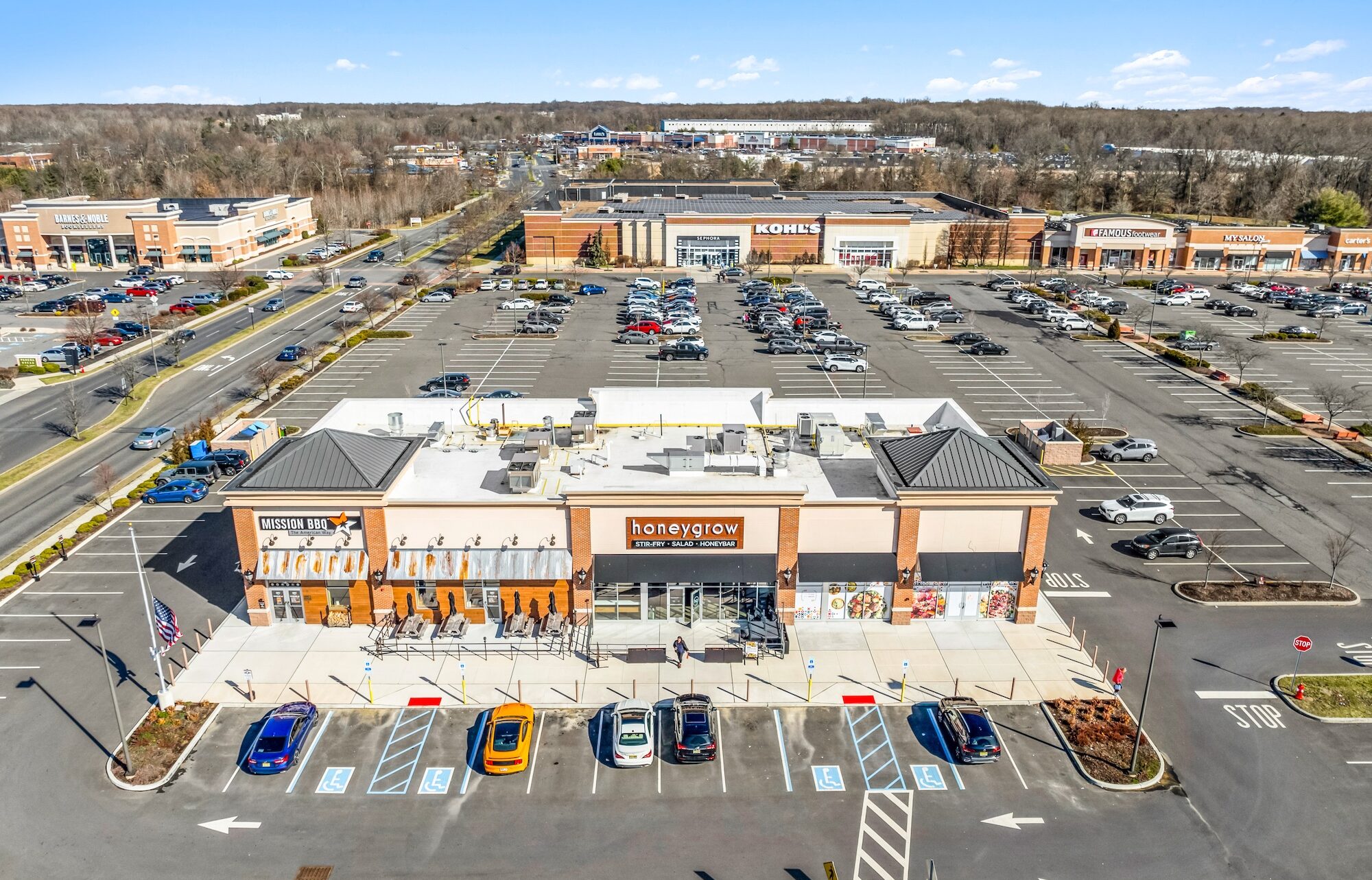 Multi tenant retail commercial real estate photography showing strip layout, tenant frontage, parking, and entry points