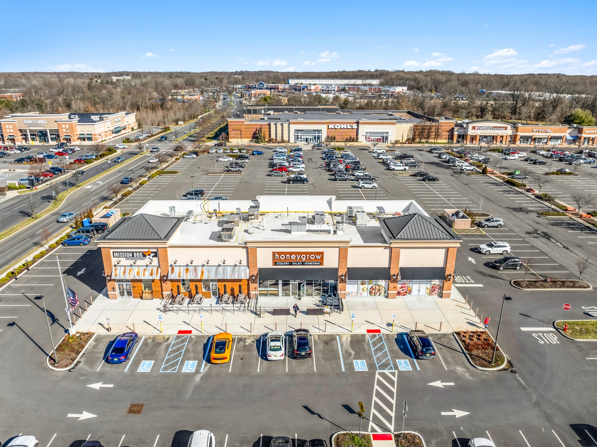 Aerial view of shopping center outparcel buildings with restaurant and retail tenants and parking