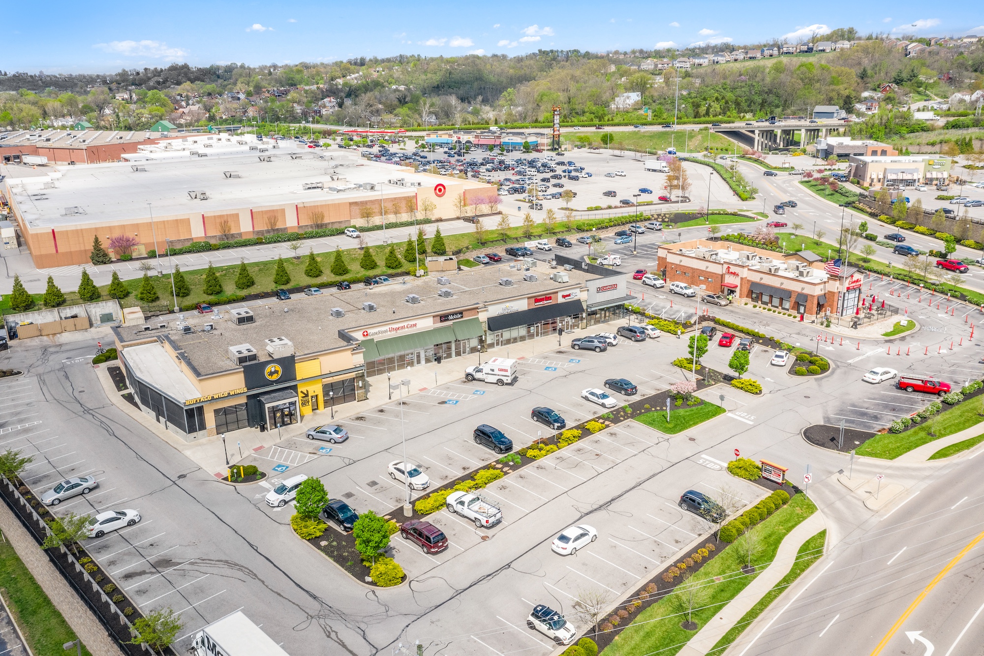 Aerial view of a power center with Target anchor, inline retail strip, and outparcel buildings