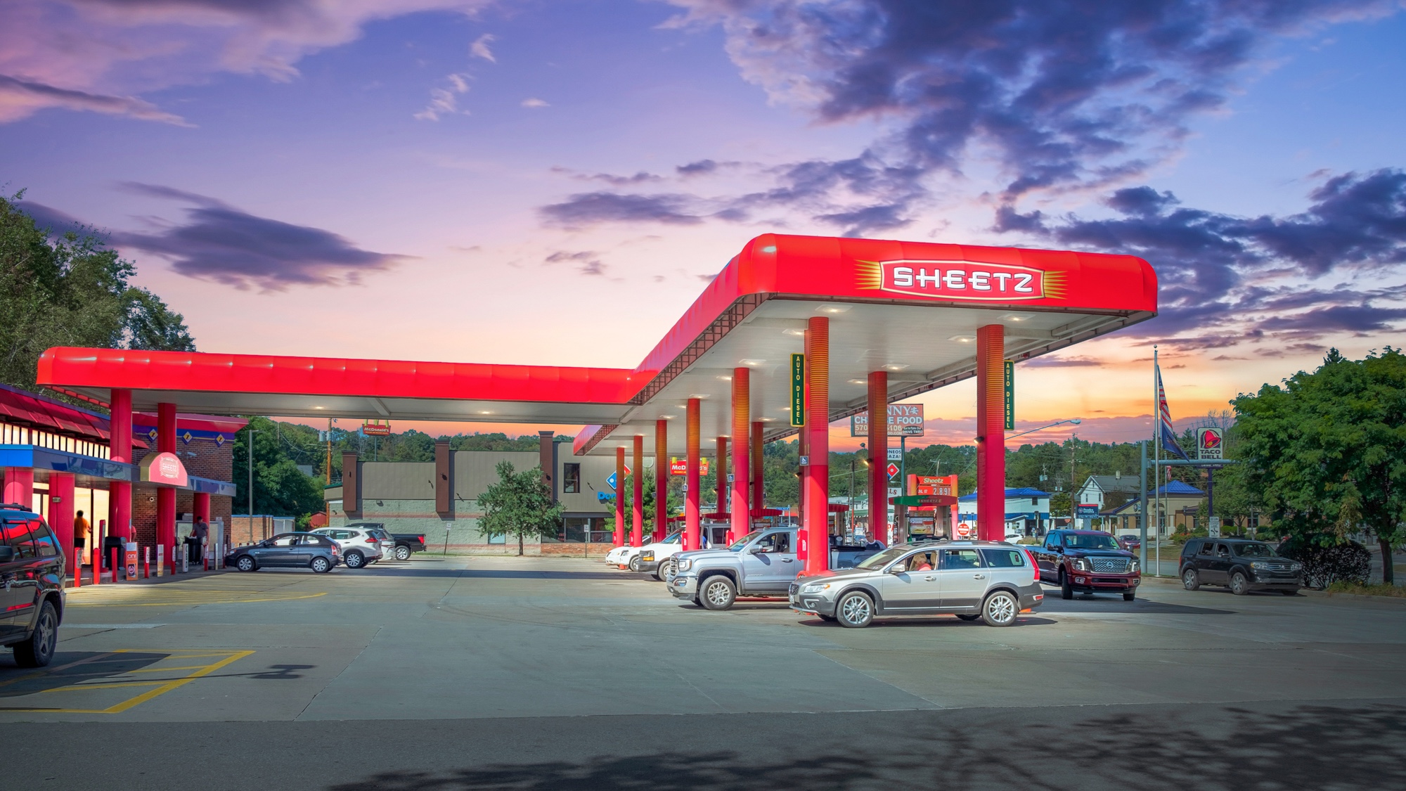 Virtual twilight of a convenience store and gas station with illuminated fuel canopy and vibrant dusk sky