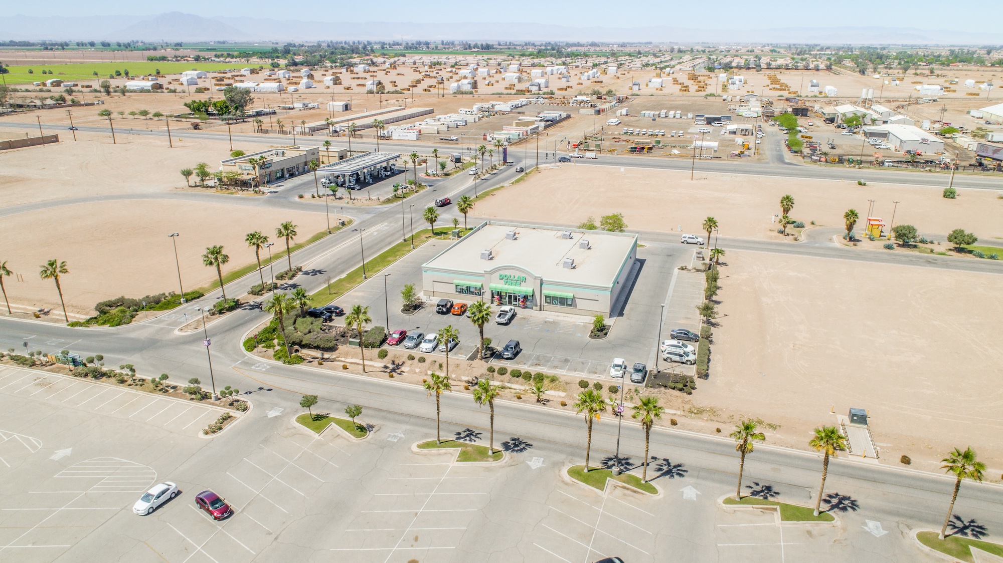Aerial view of a single-tenant Dollar Tree property with parking, road access, and surrounding commercial area