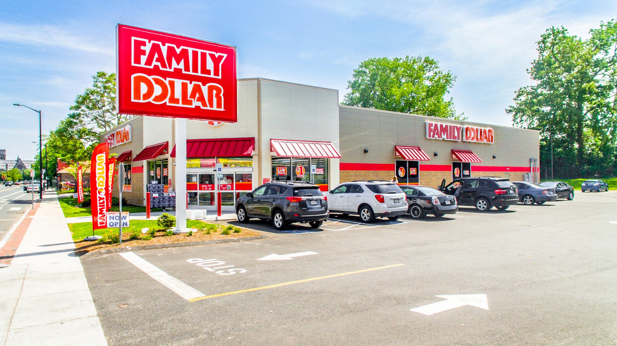 Ground-level photograph of a Family Dollar store with prominent monument signage, facade, and parking