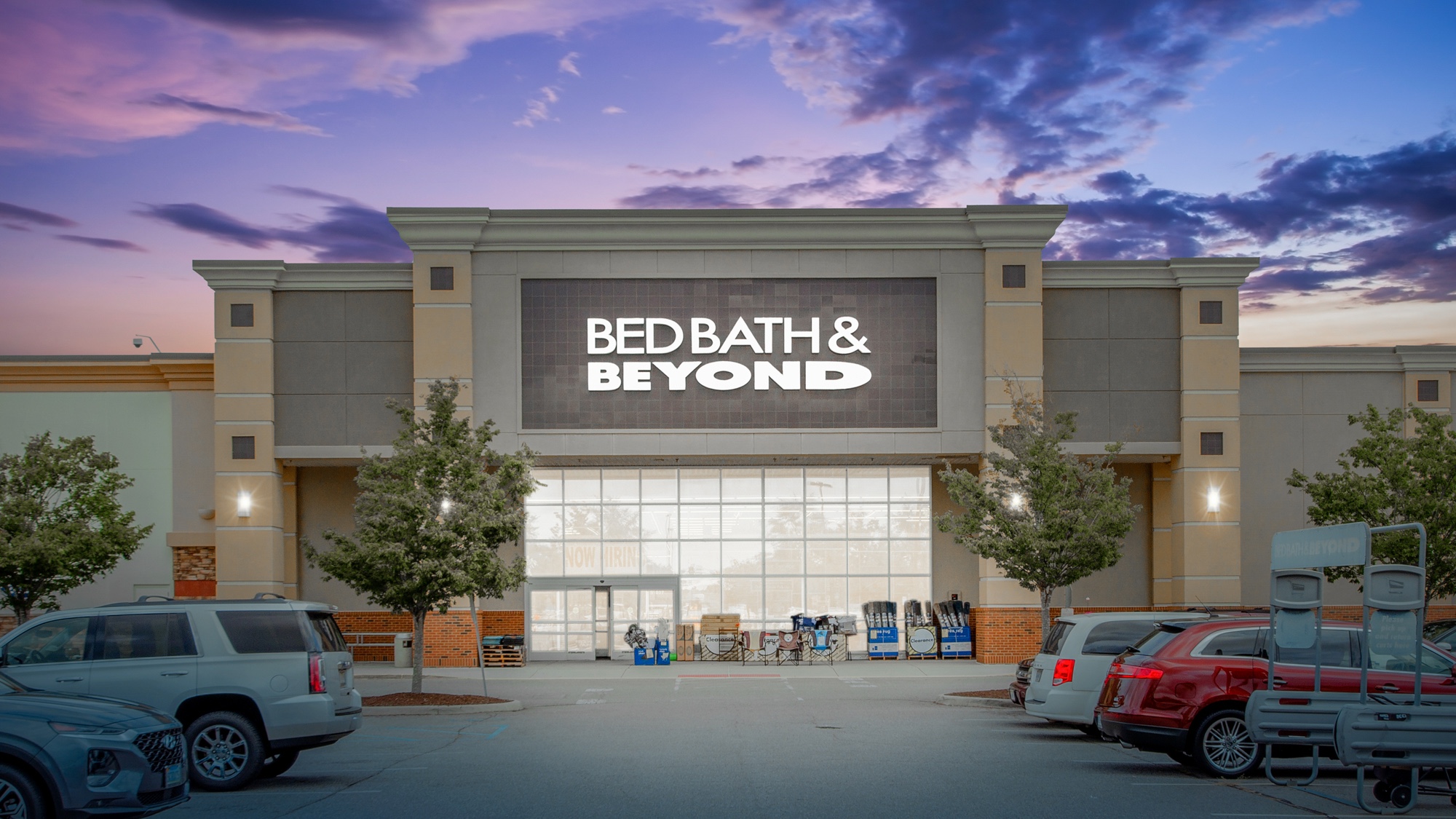 Virtual twilight of a large-format retail building with illuminated signage and vibrant dusk sky