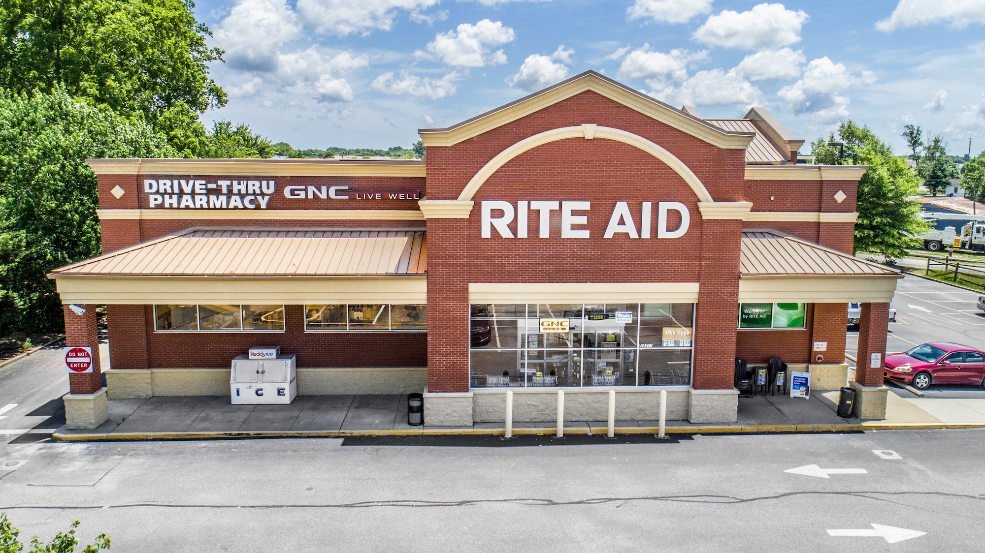 Low-altitude photograph of a pharmacy storefront with drive-through pharmacy signage and building facade