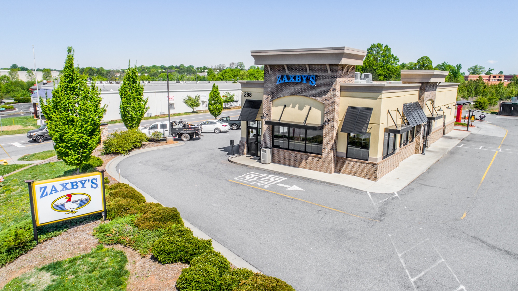 Single-tenant QSR property with monument signage, drive-through entrance, and landscaped parking area