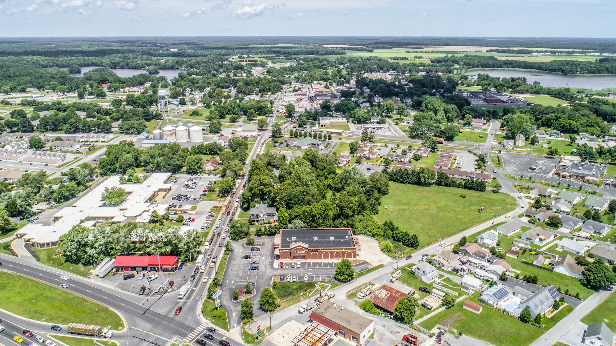 High-altitude aerial of a single-tenant property in a small-town retail corridor with surrounding community