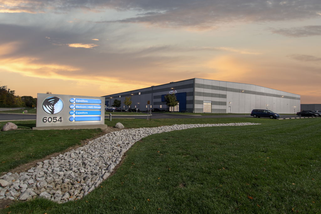 Ground-level twilight photography of industrial distribution warehouse with tenant signage