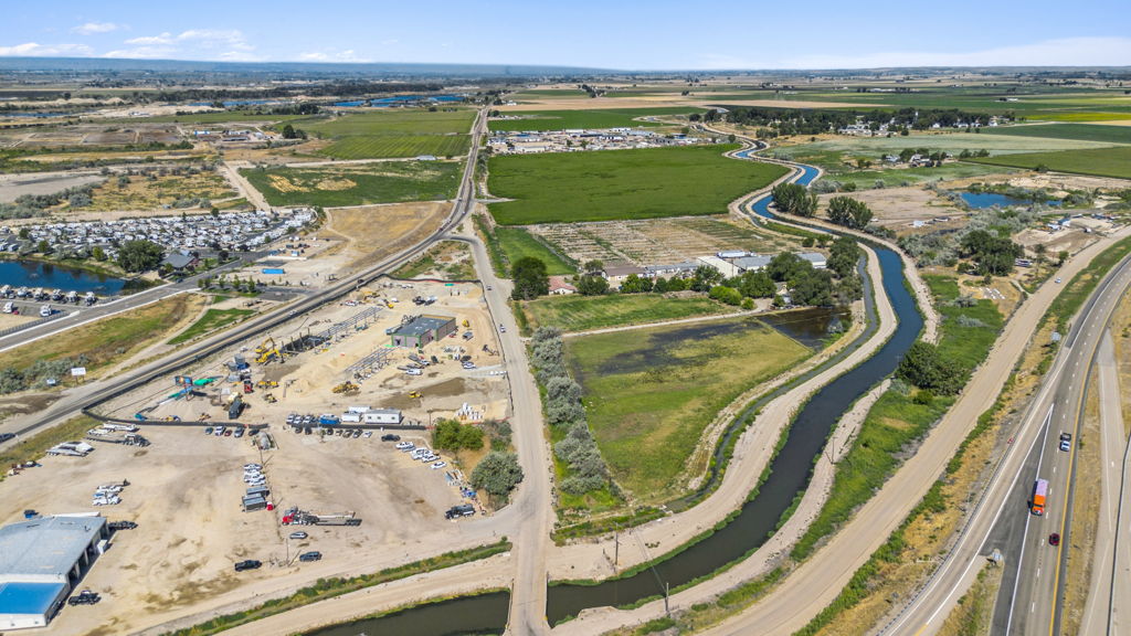Aerial drone photography of commercial land parcel near highway with canal and surrounding farmland