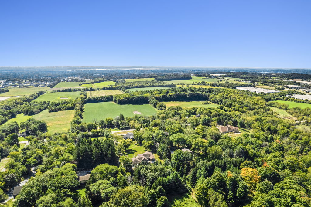 High-altitude aerial view of rural land parcel with agricultural fields and tree coverage
