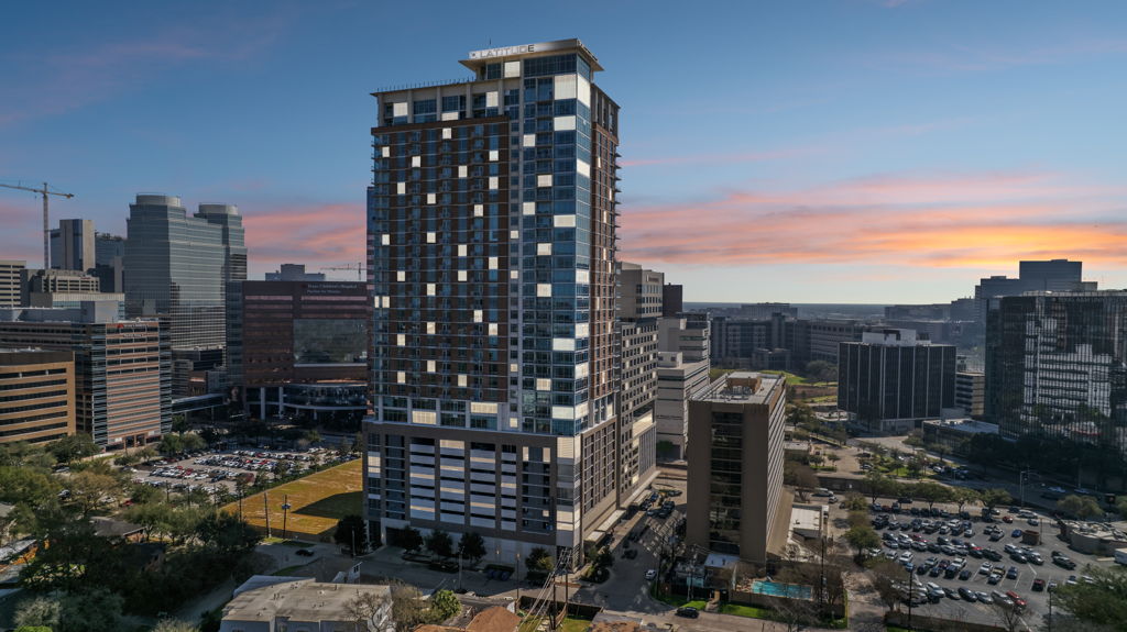 Twilight aerial drone photography of luxury high-rise apartment tower in urban medical district