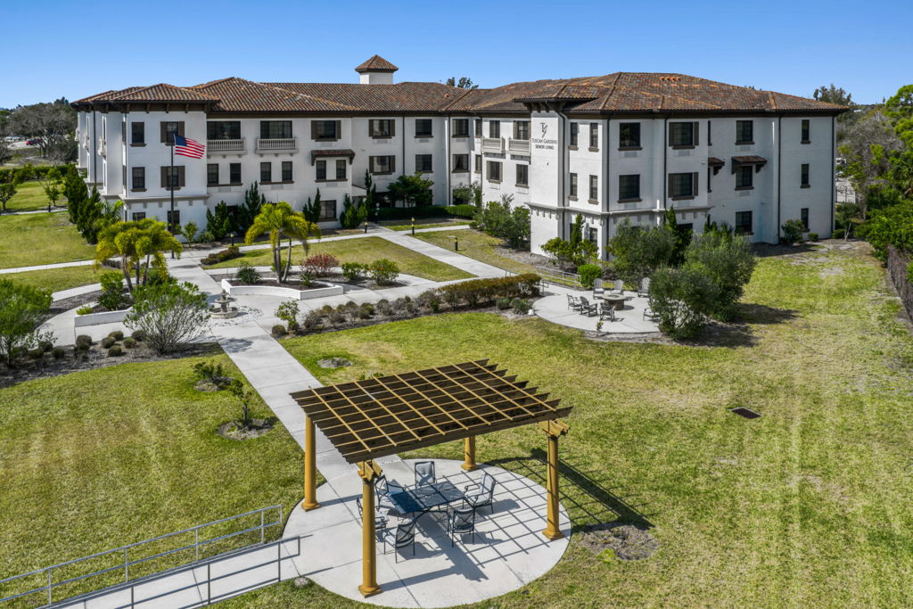 Aerial drone photography of senior living community with Mediterranean architecture and courtyard pergola