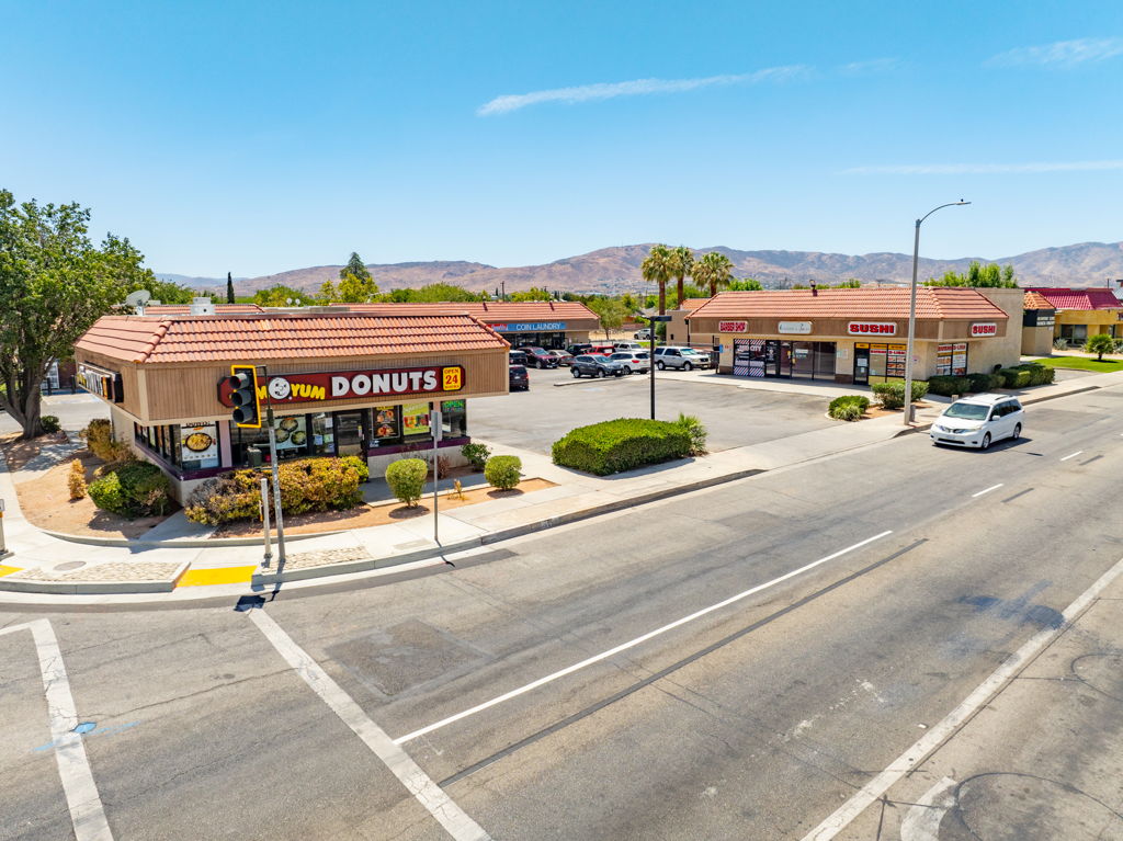 Aerial drone photography of grocery-anchored multi-tenant retail center with full tenant occupancy