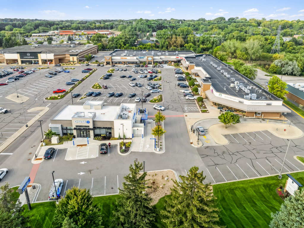 Aerial drone photography of multi-tenant strip center with bank outparcel and inline retail tenants