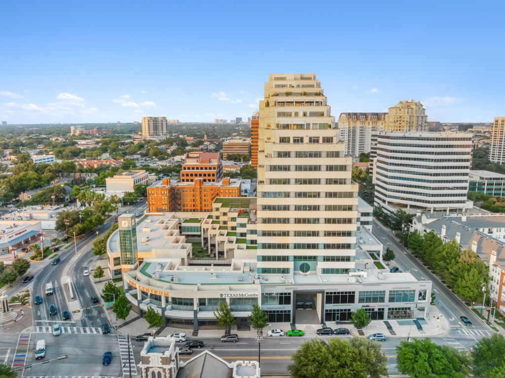Aerial view of urban office tower showing surrounding downtown city context and street-level retail