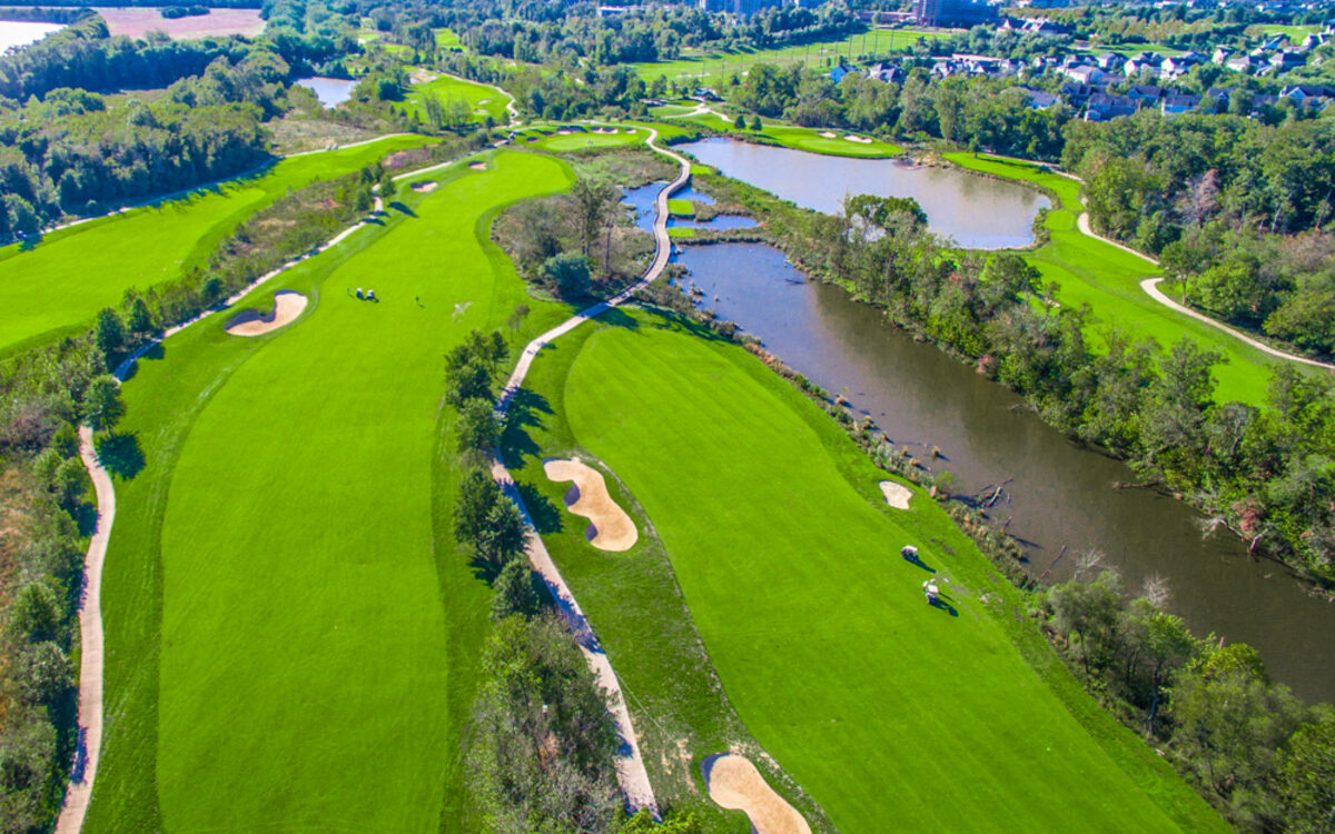 Aerial photography of a golf course showing fairways, greens, water features, and surrounding landscape