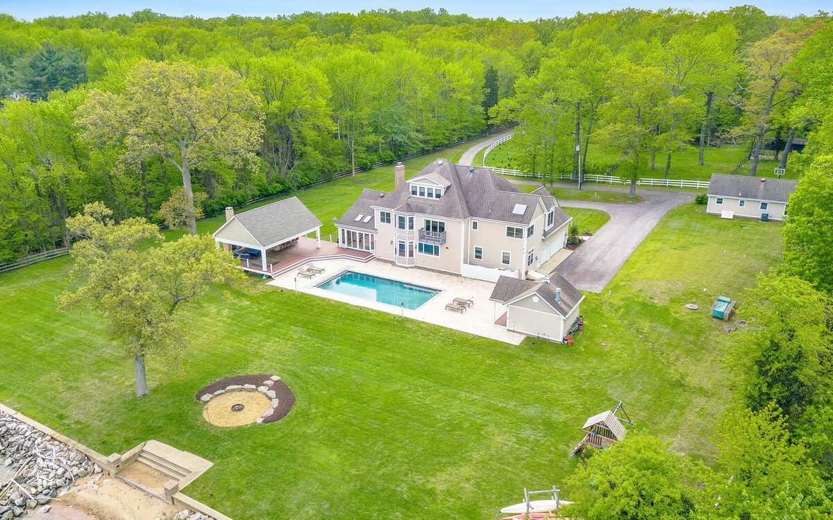 Aerial photography of a residential estate showing home, pool, yard, and surrounding landscape