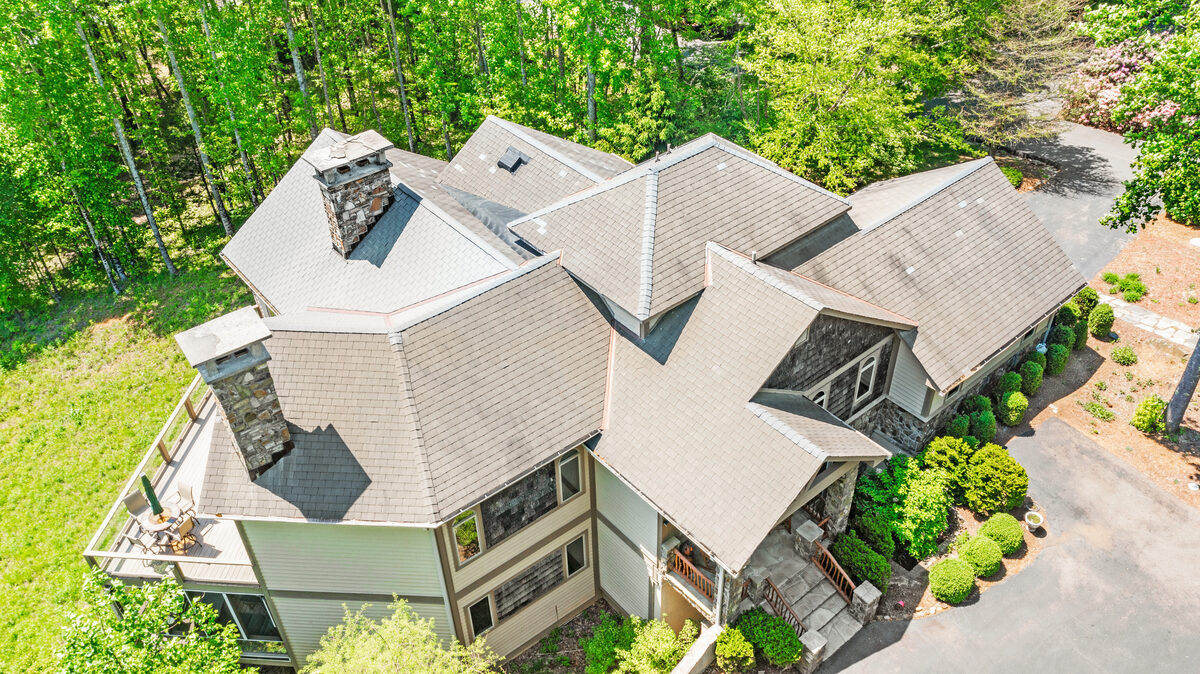 Aerial roof inspection photography showing rooftop detail, chimneys, and surrounding landscape from above