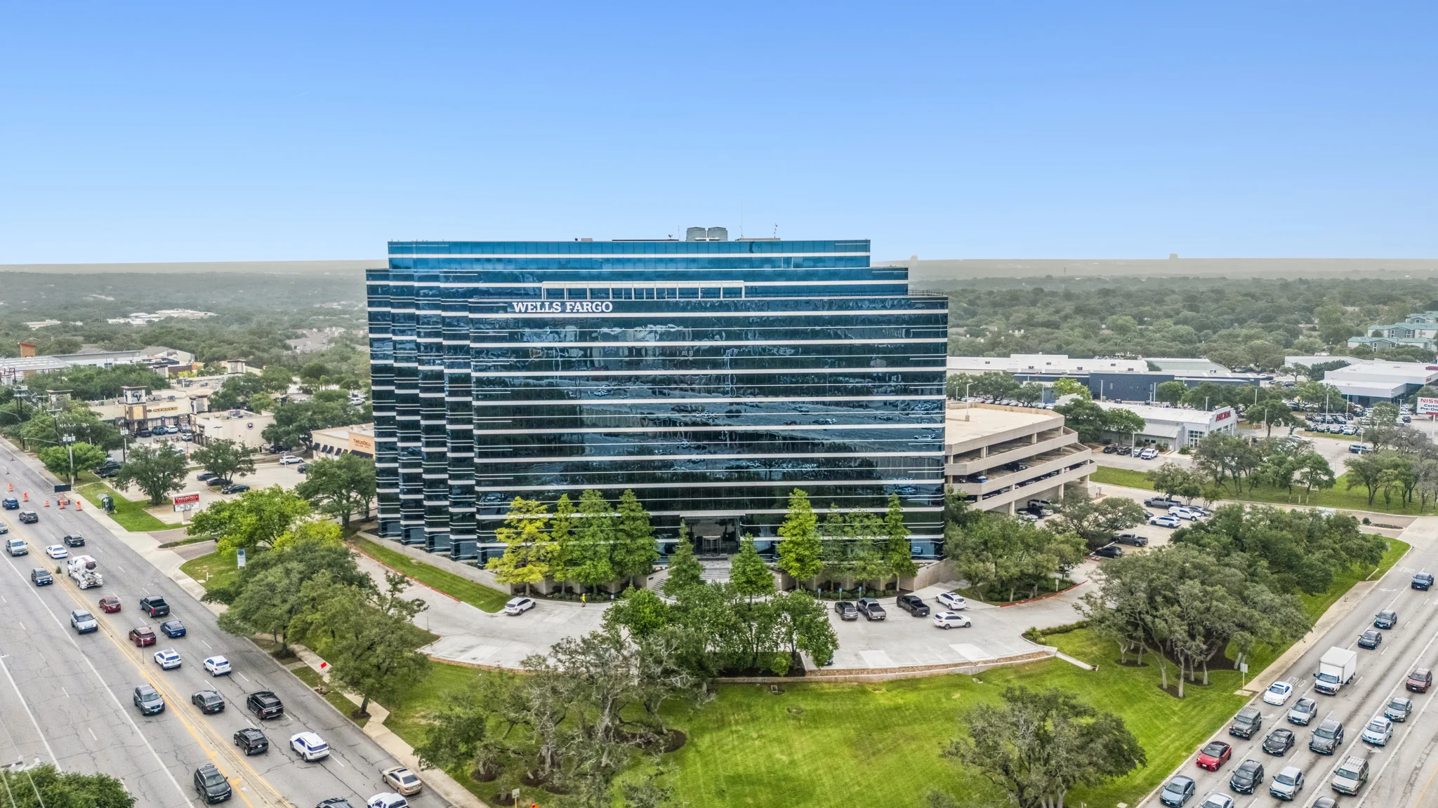 Corporate headquarters glass tower with reflective curtain wall along highway corridor