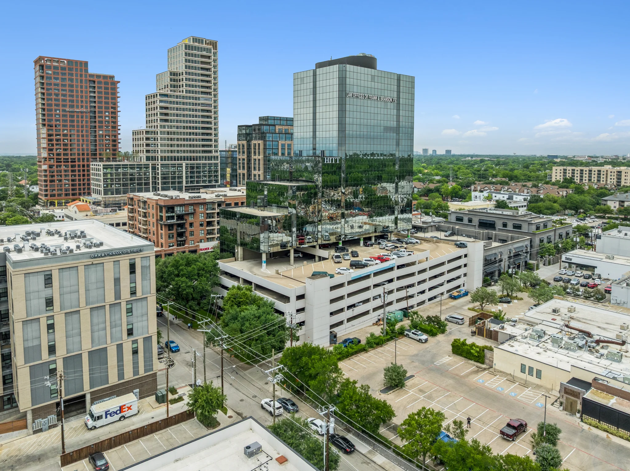 Urban corporate headquarters high-rise with reflective glass facade and integrated parking