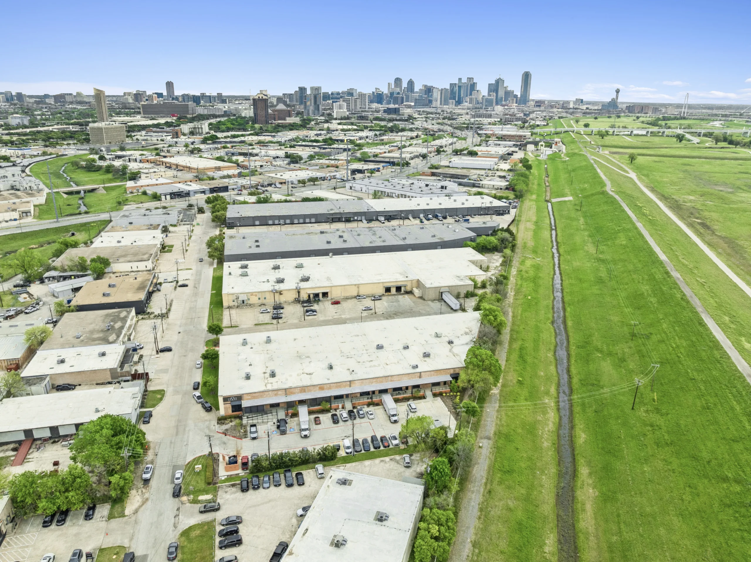 Aerial drone photography of industrial corridor with city skyline and rail access