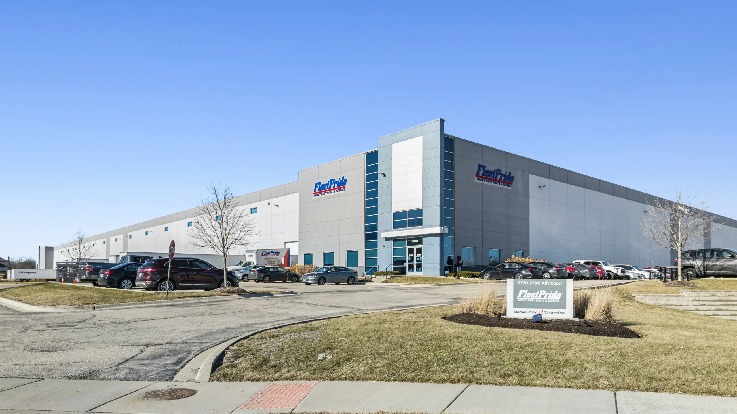 Ground-level photography of industrial distribution center entrance with monument signage