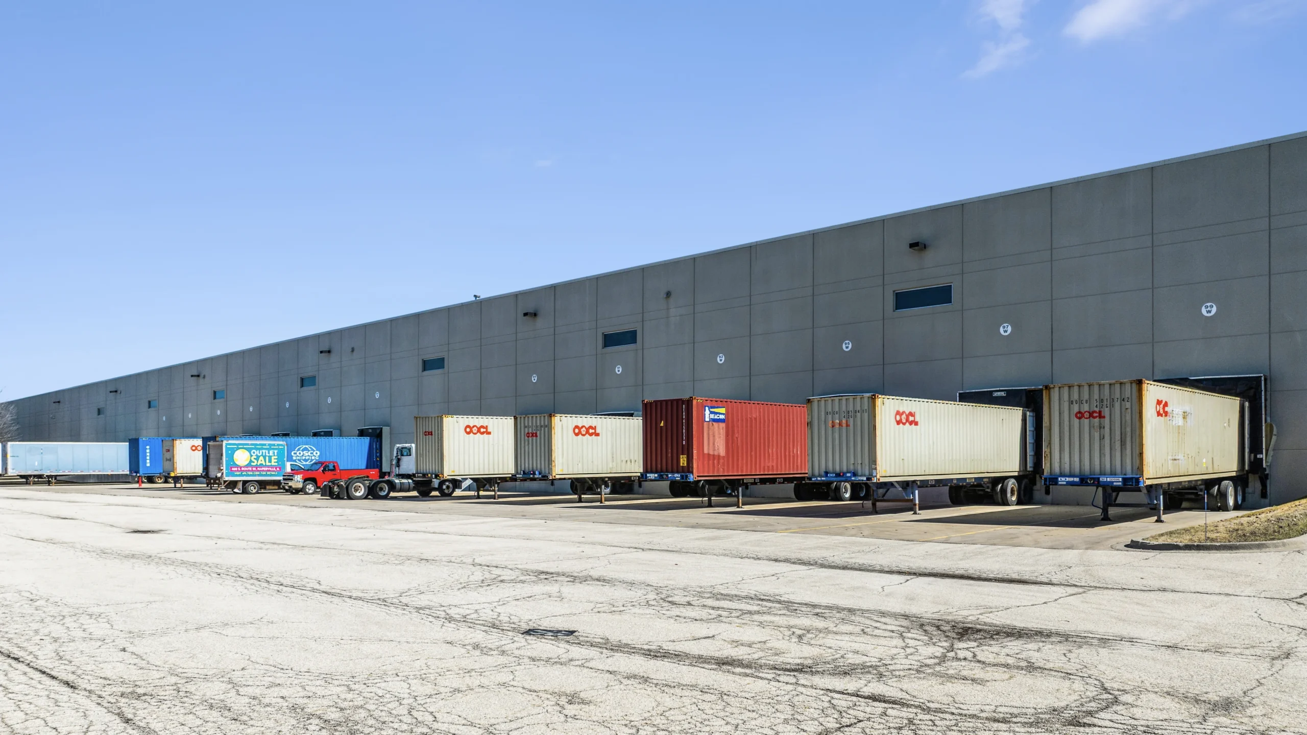 Ground-level photography of distribution center loading docks with shipping containers