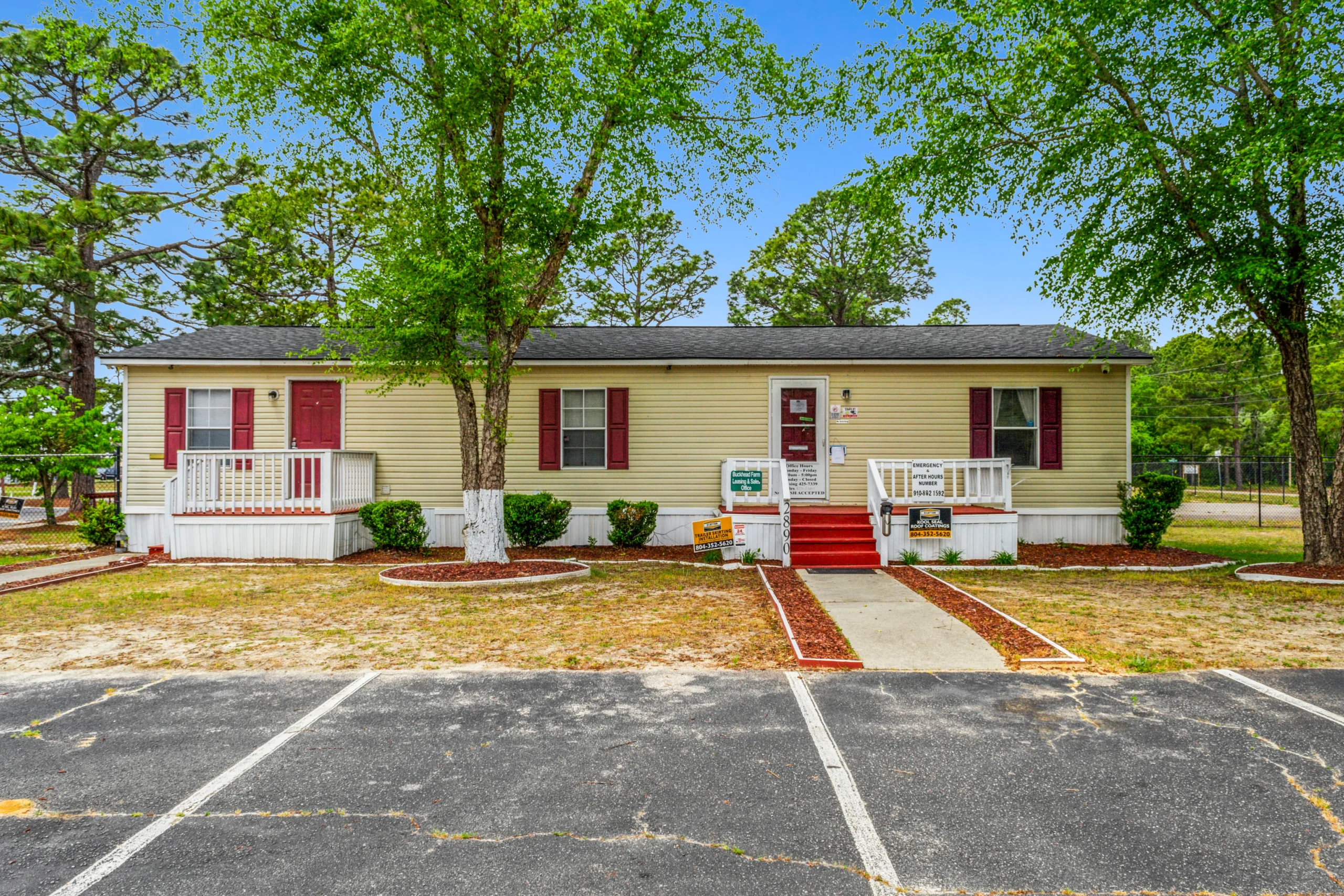 Ground-level photography of mobile home community leasing office building with parking