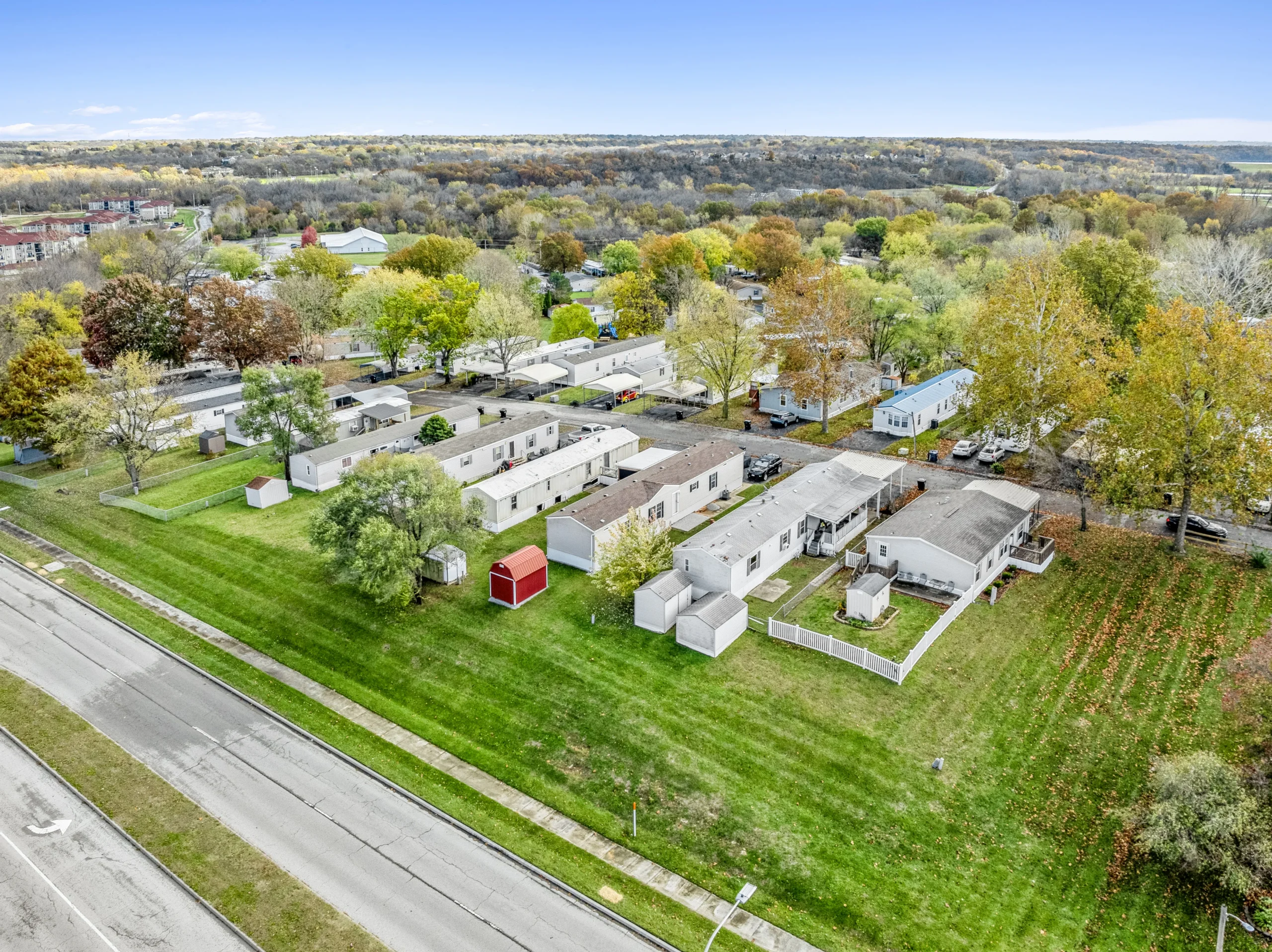 Aerial drone photography of midwestern mobile home community along road with fall foliage
