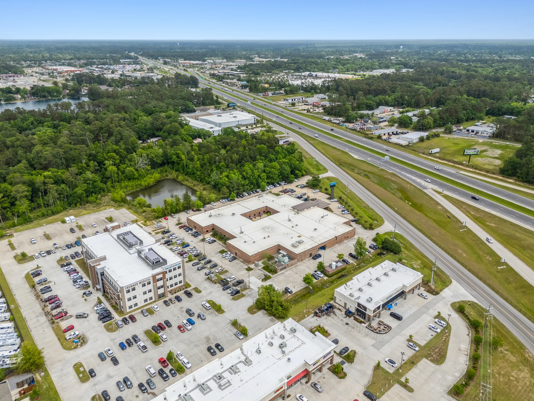 Aerial view of medical office building campus with multiple medical buildings and patient parking along highway frontage
