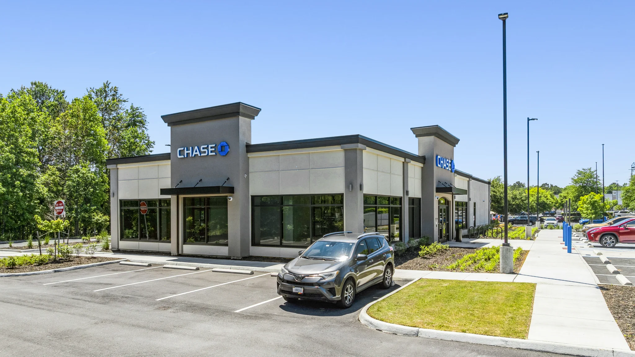 Aerial photograph of a single-tenant US Bank branch with brick architecture, landscaped entrance, and customer parking field