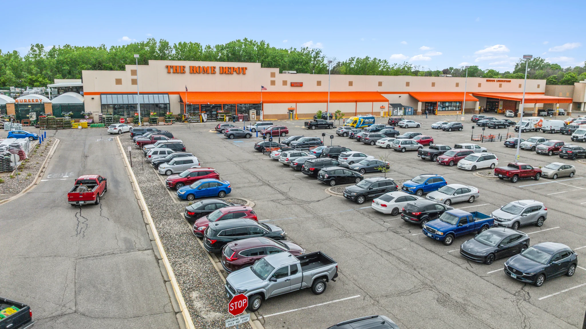 Ground-level photograph of a single-tenant Walmart big-box store with home and pharmacy and market entrances, branded signage, and large parking field