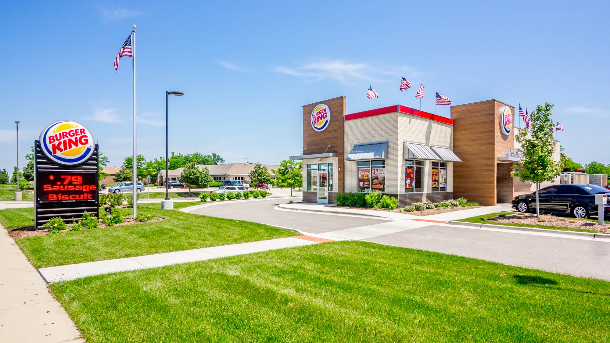 Aerial view of a single-tenant Burger King restaurant with monument pylon signage, drive-through lane, and landscaped corner lot