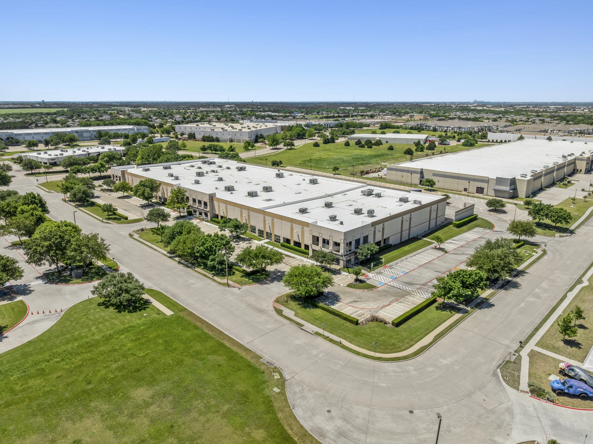 Aerial view of suburban office park campus with multiple buildings and shared parking
