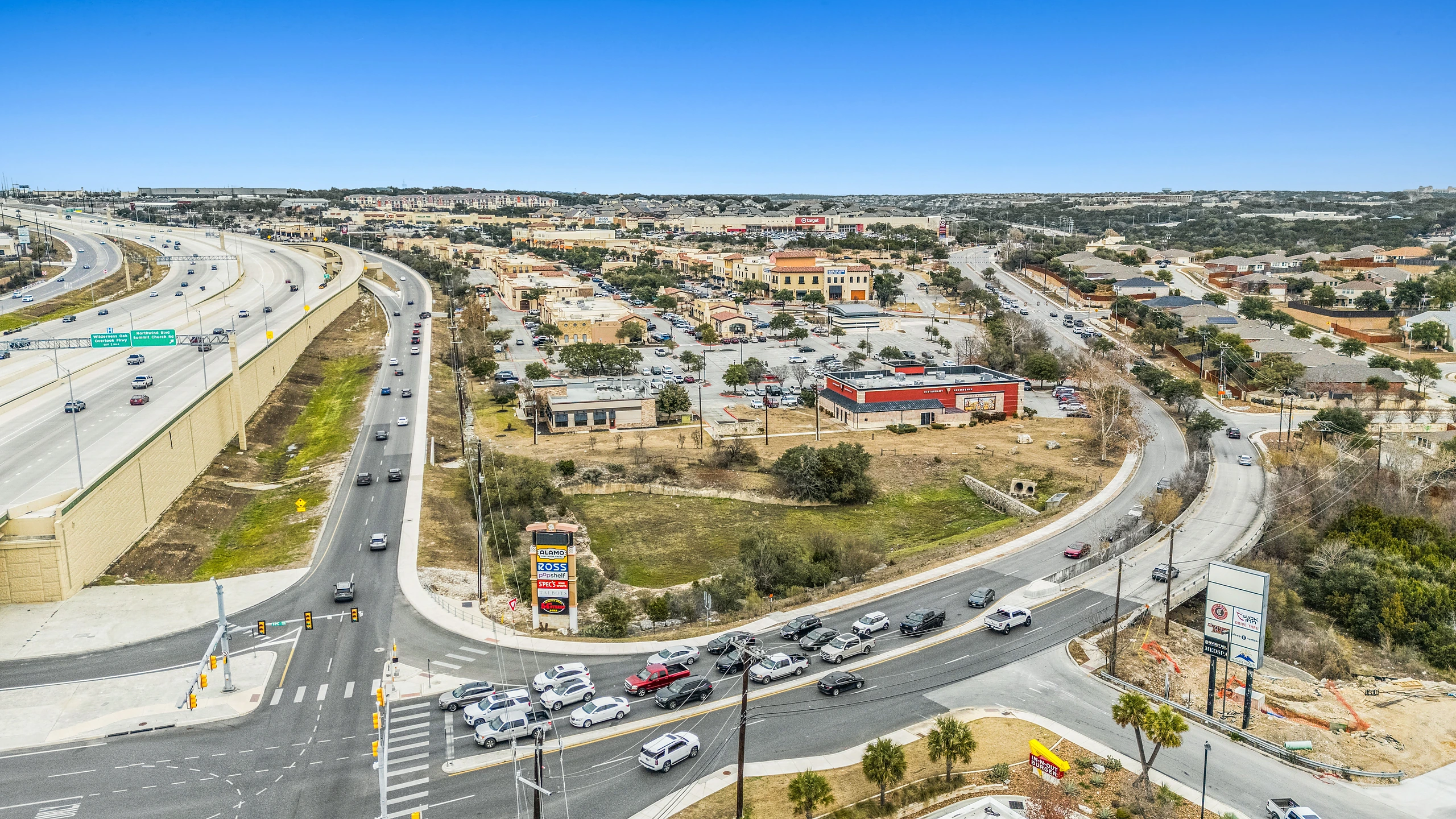 Aerial photograph of multi-tenant retail development clustered around a major highway interchange