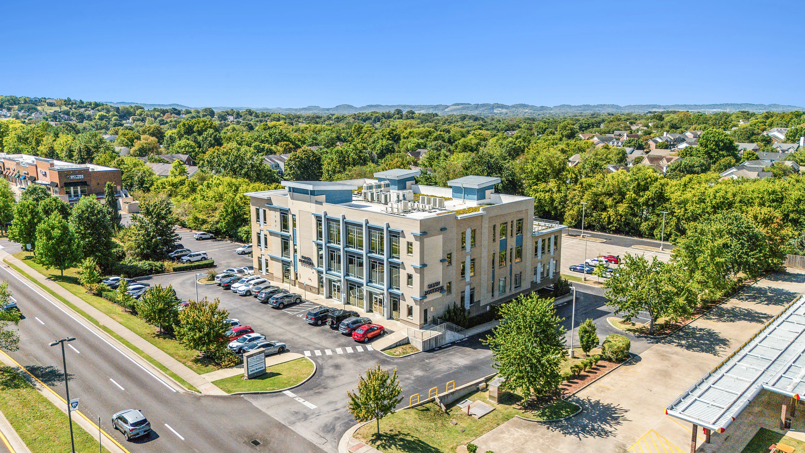 Aerial photograph of a multi-story mixed-use building combining ground-floor retail with residential above