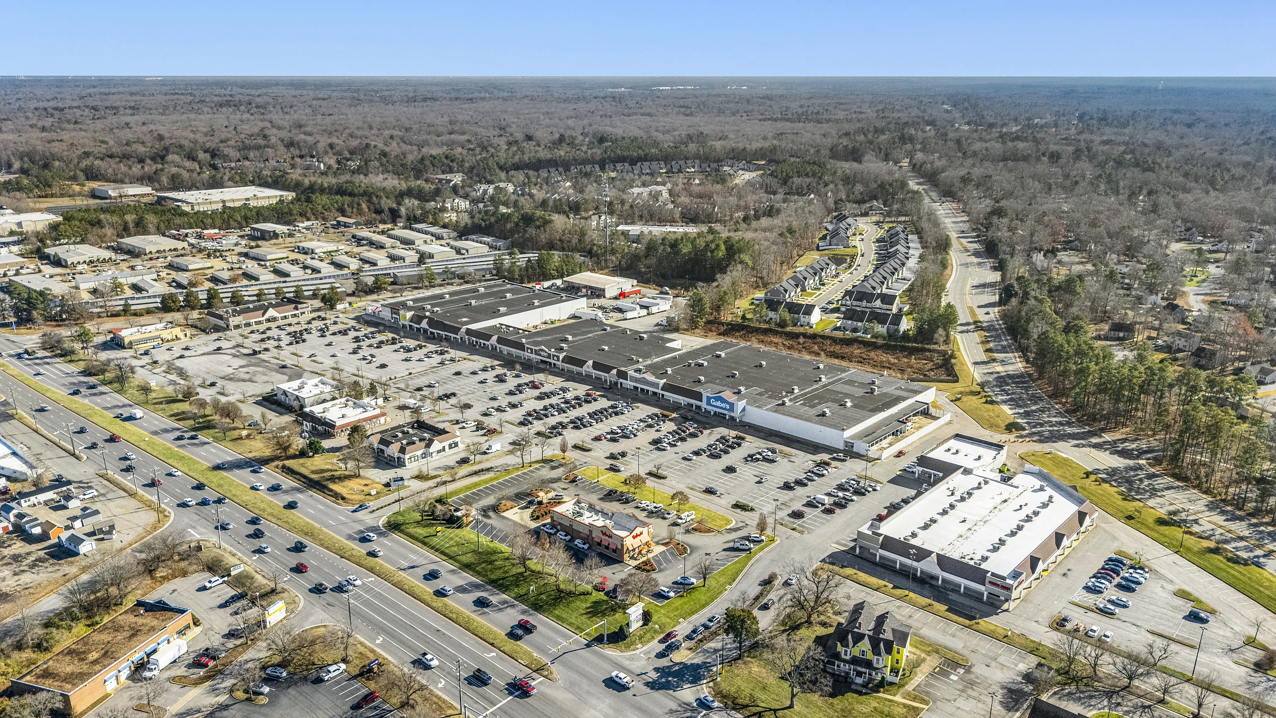 High-altitude aerial of a multi-tenant retail corridor showing several centers and the surrounding trade area
