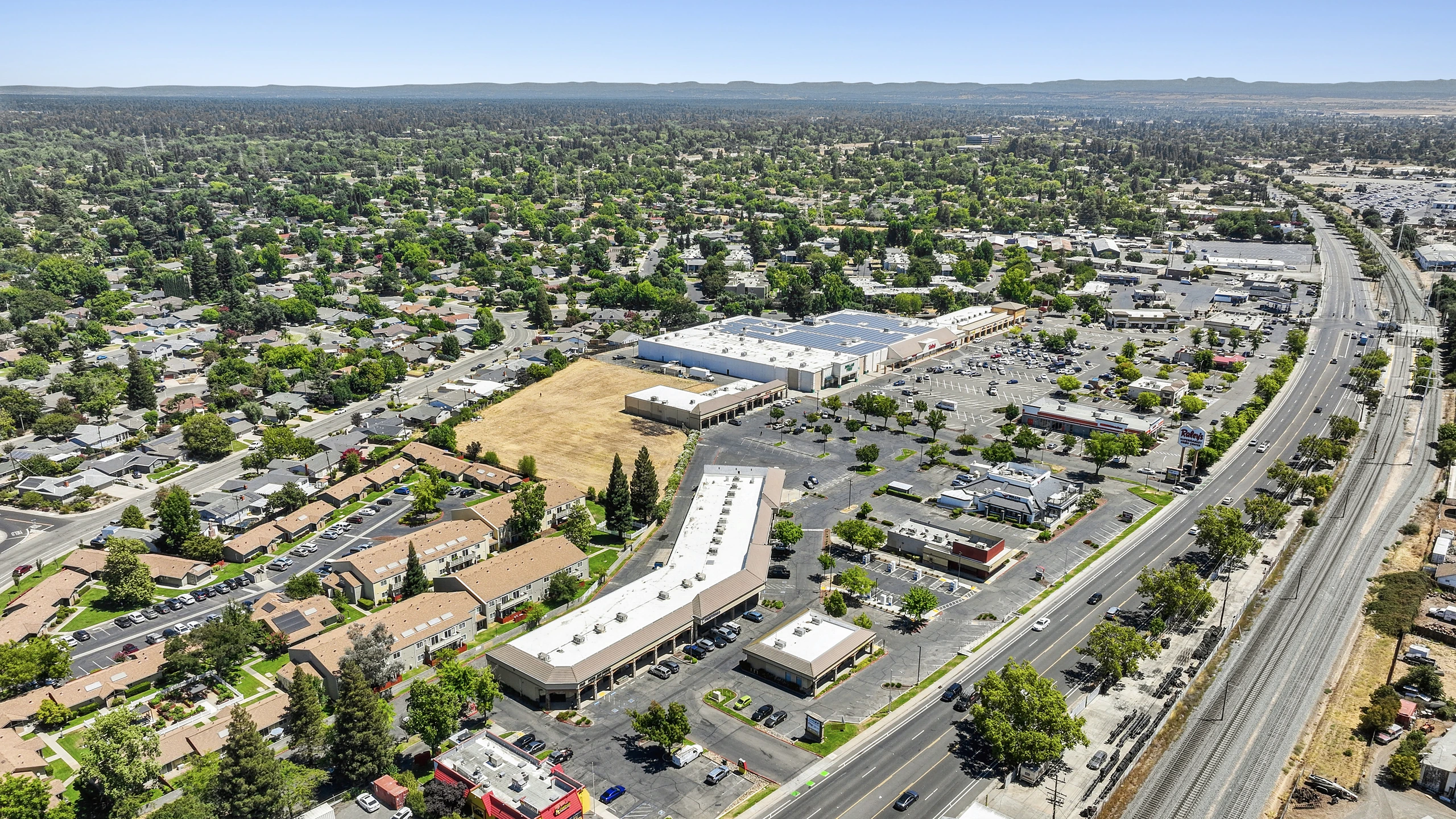 Aerial photograph of a power center along a transit and highway corridor with surrounding development
